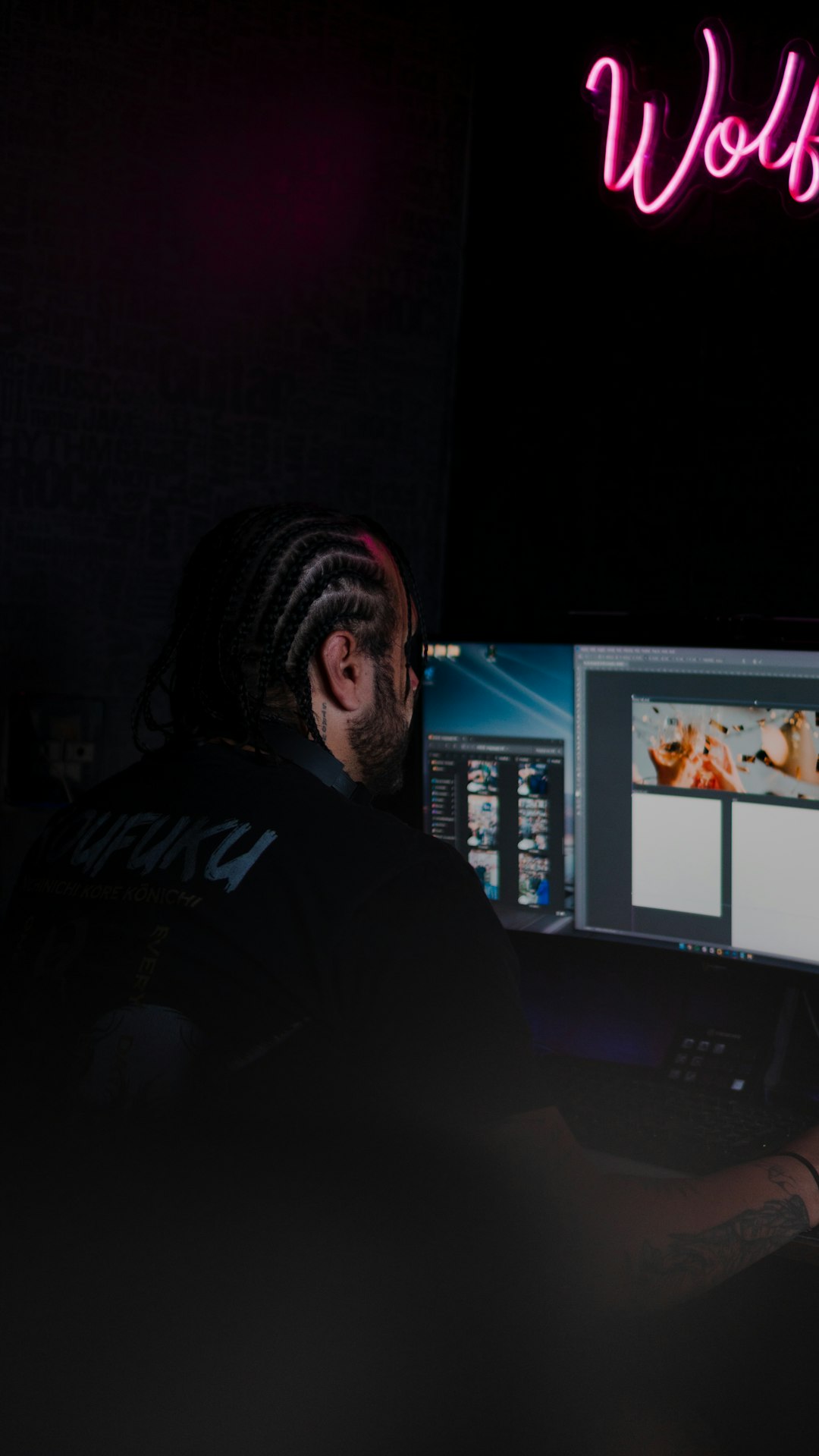 Man with braids working on computer with neon sign agency team, client websites, maintenance workflow, support tickets