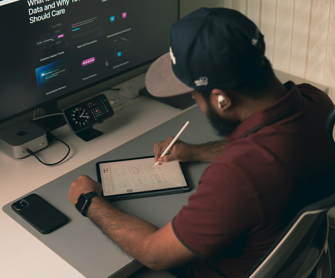Man working at a desk with computer and tablet designer desk app sketches wireframe tools