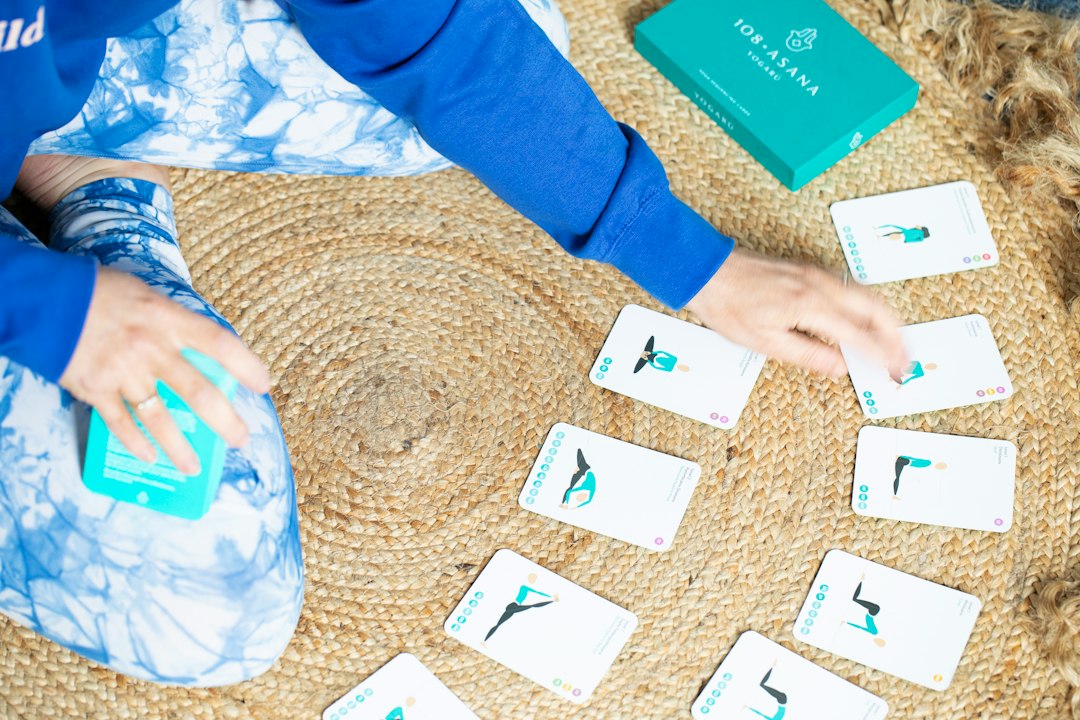 Person arranging yoga pose cards on a rug visual schedule, calming colors, routine cards