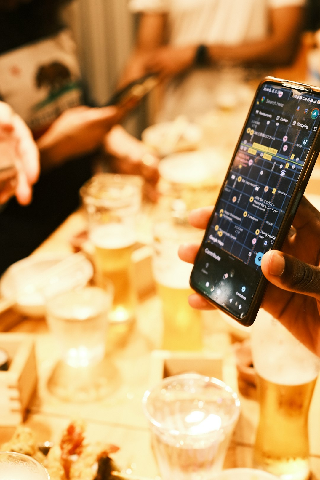 Person holding smartphone with map app over drinks voice search, local map, artificial intelligence