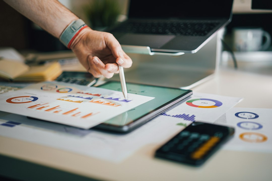 person using stylus on tablet with charts marketing budget, small business team, analytics report