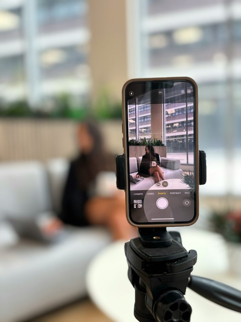 Smartphone recording a woman on a couch instagram reel analytics, watch time, shares, saves
