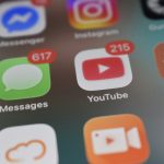 Smartphone screen showing app icons with red notification badges for Messages and YouTube video sharing apps, cloud upload, compressed video