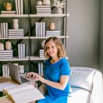 Smiling woman working on laptop at a desk small business owner, email comparison, office desk