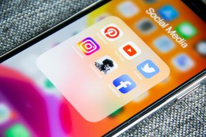Social media app icons on a smartphone screen with a textured grey background social media gif, reaction clip, sharing platform