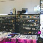 Store interior with shelves of merchandise and items on tables console storefront, game preorder, digital download