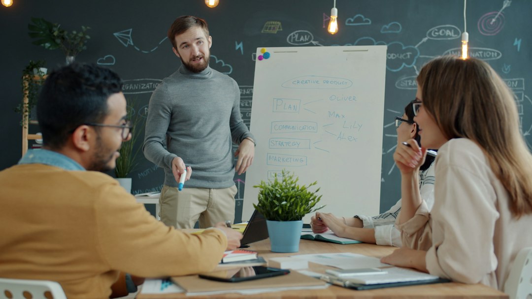 Team collaborating around a whiteboard during a meeting team voting, whiteboard, name ideas, happy coworkers