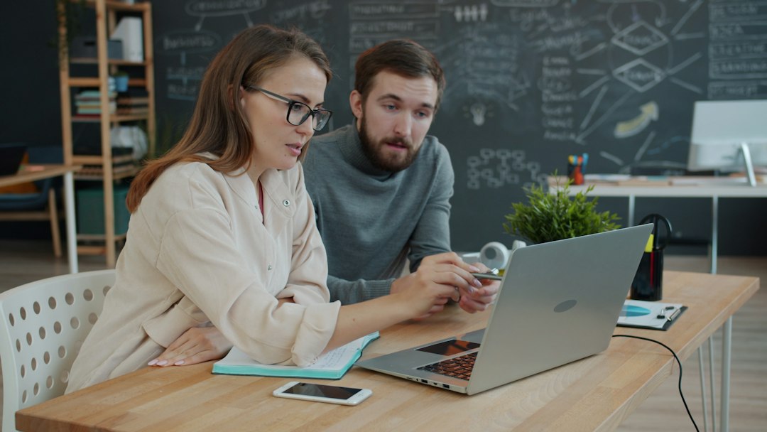 Two colleagues collaborating on a project at a laptop career growth, project management, office success