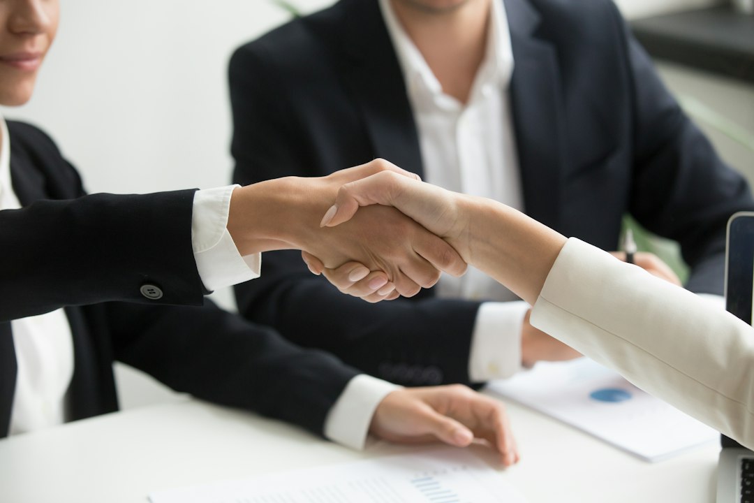 two people shaking hands in front of a laptop sales pipeline, deal closing, contract review, revenue team