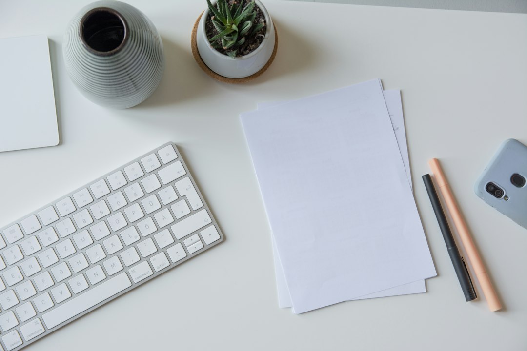 white printer paper beside white apple keyboard content brief, keyword research, writing desk