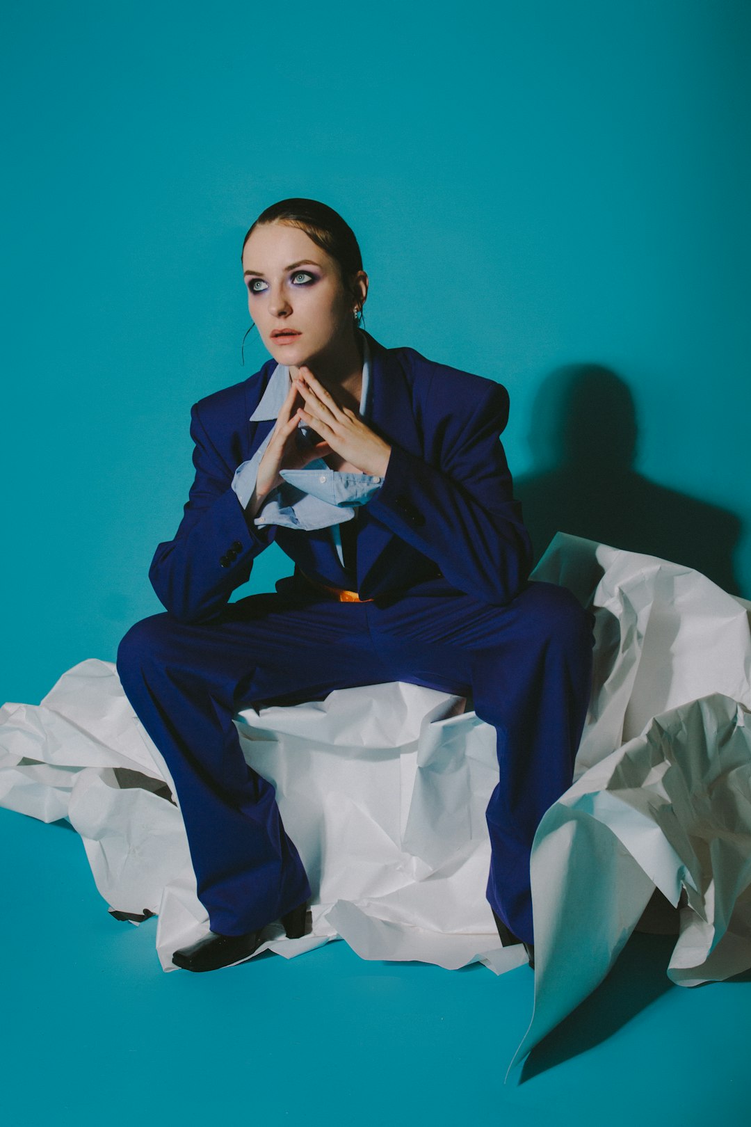 woman in black blazer sitting on bed cinematic portrait, studio lighting, fashion editorial