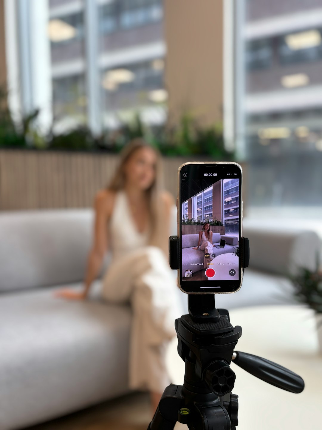 Woman recording herself on a smartphone tripod creator planning reel, content checklist, phone tripod