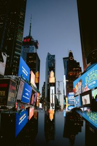 a city street with many billboards corporate crisis newsroom, public relations team, media monitoring