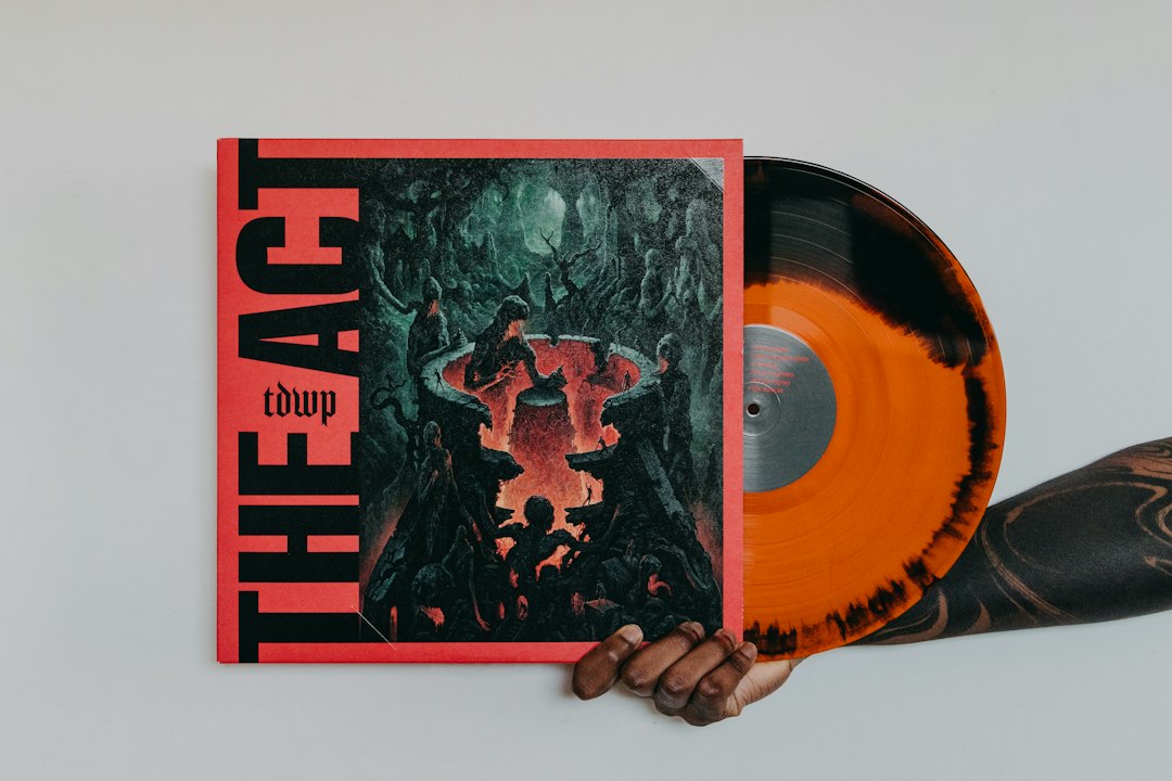 a hand holding an orange and black vinyl album album cover design music art