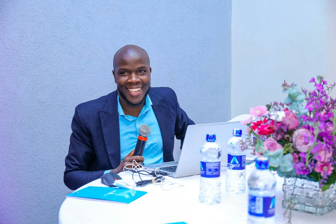 A man sitting at a table with a laptop health journalist interview, pharmaceutical spokesperson, press briefing