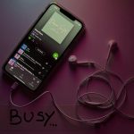 black android smartphone on white surface music app interface, playlist screen, dark theme