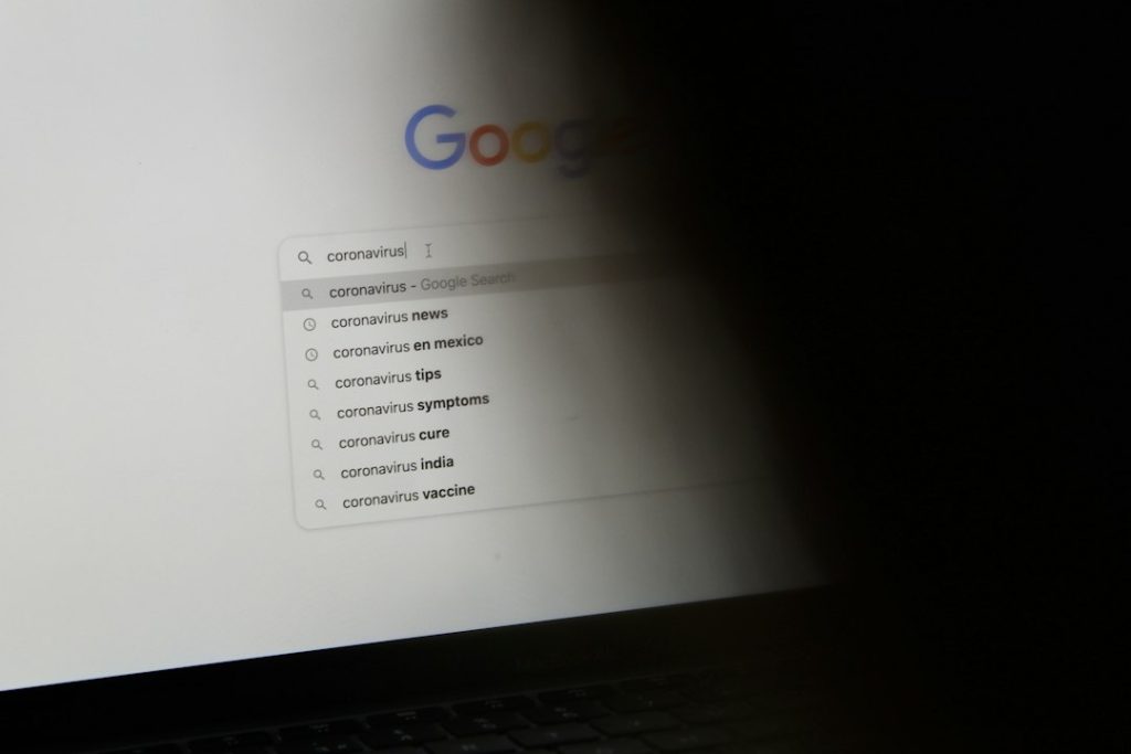black laptop computer turned on displaying google search google docs toolbar, text formatting, strikethrough menu