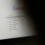 black laptop computer turned on displaying google search google docs toolbar, text formatting, strikethrough menu