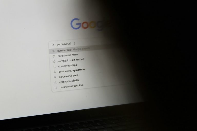 black laptop computer turned on displaying google search google docs toolbar, text formatting, strikethrough menu