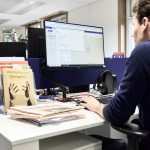 Man working at a computer in an office wordpress staging, website redesign, private workspace