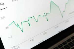 stock market chart displayed on laptop screen marketing analytics chart, customer segments, ecommerce reports, revenue trends