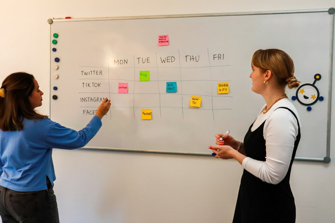 two women standing in front of a whiteboard with sticky notes on it project dashboard, task timeline, team planning