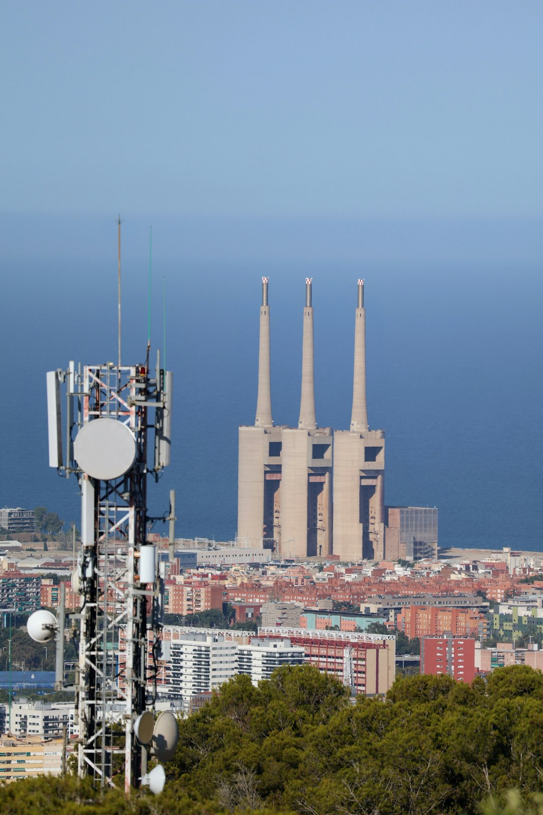 Urban landscape with telecommunications tower and power plant chimneys smartphones, coverage map, city towers