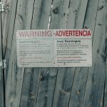Wooden gate with a warning sign rejected ad warning, policy review, red alert